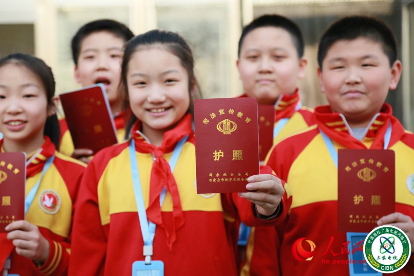 图为石家庄市和平西路小学的孩子们在展示自己的税务护照。